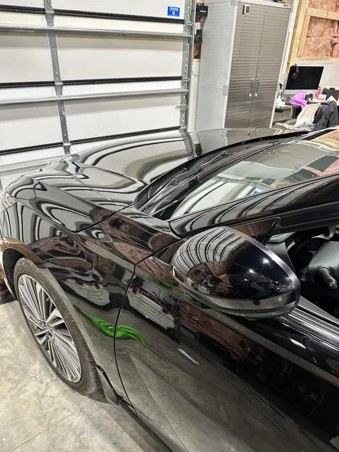 Mirror finish on a black sedan after paint correction